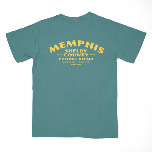 Green t-shirt with "Pothole Repair Shirt on Blue Spruce" print on the back from Choose901 Merch Shop.
