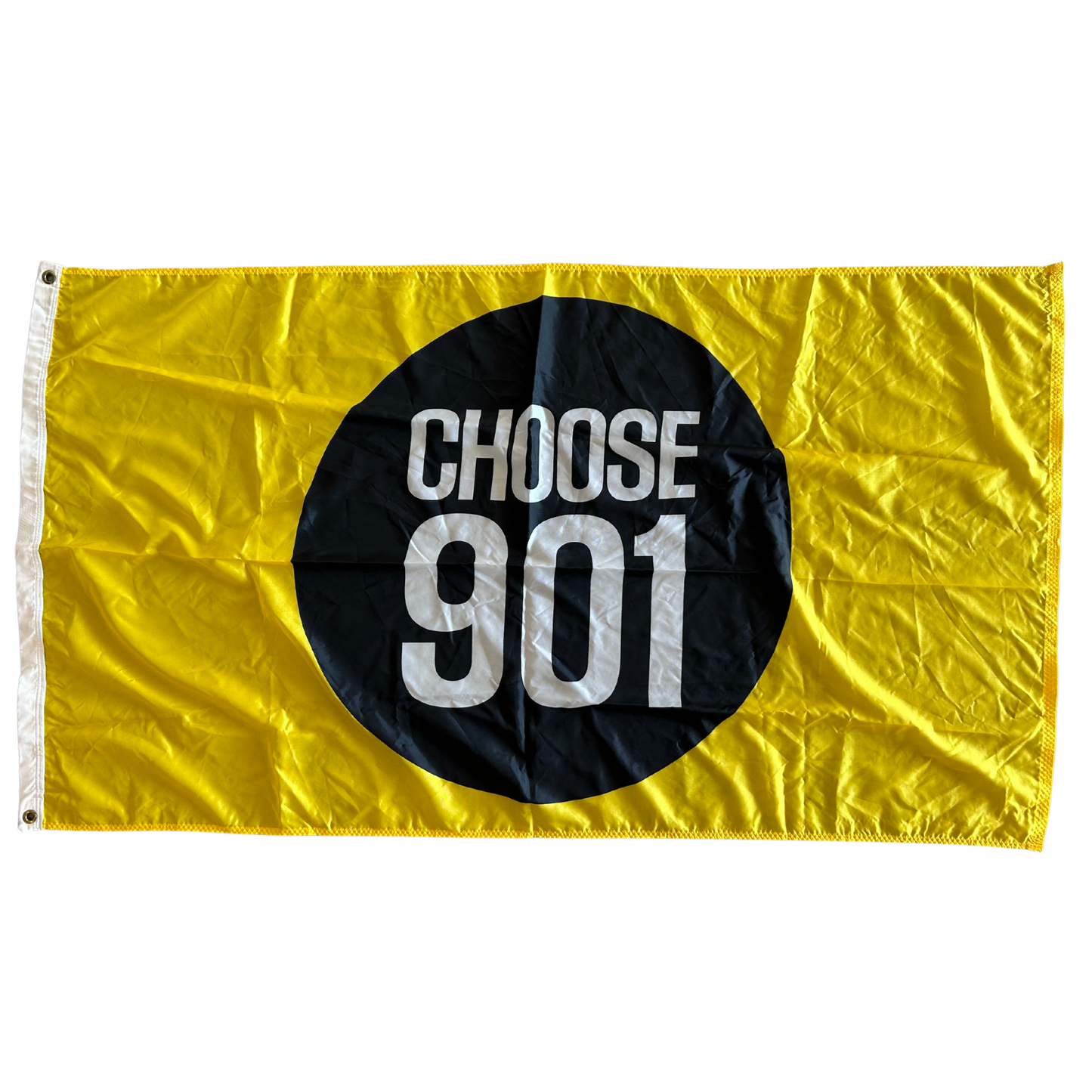 A CHOOSE901 FLAG from the Choose901 Merch Shop, featuring the words "CHOOSE 901" in white letters inside a large black circle on a yellow background, waves proudly outside homes along Poplar Ave.