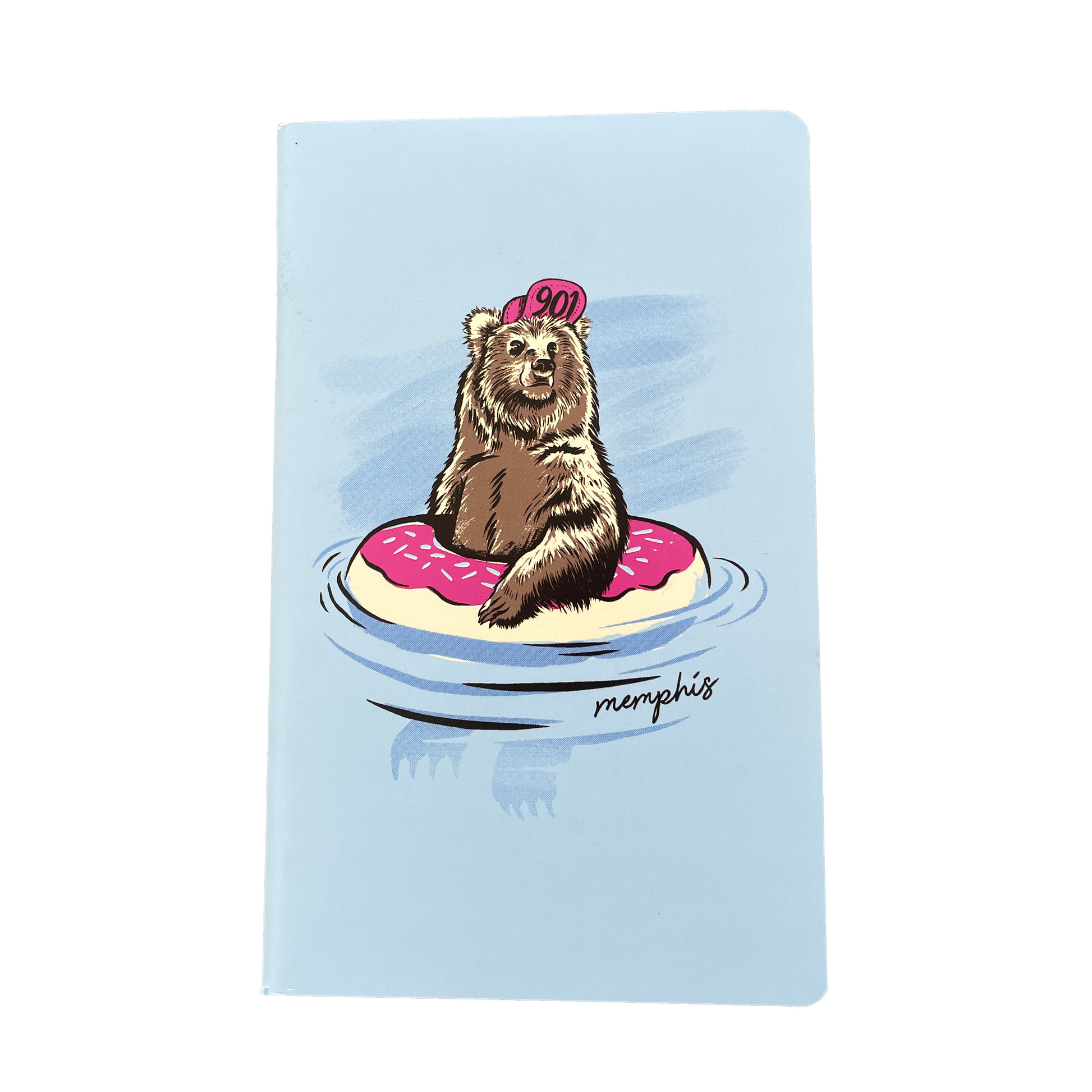 A large light blue notebook from the Choose901 Merch Shop features a bear in a pink cap relaxing on a pink frosted donut float on its cover, with "Memphis" elegantly inscribed at the bottom and dot graph pages inside.
