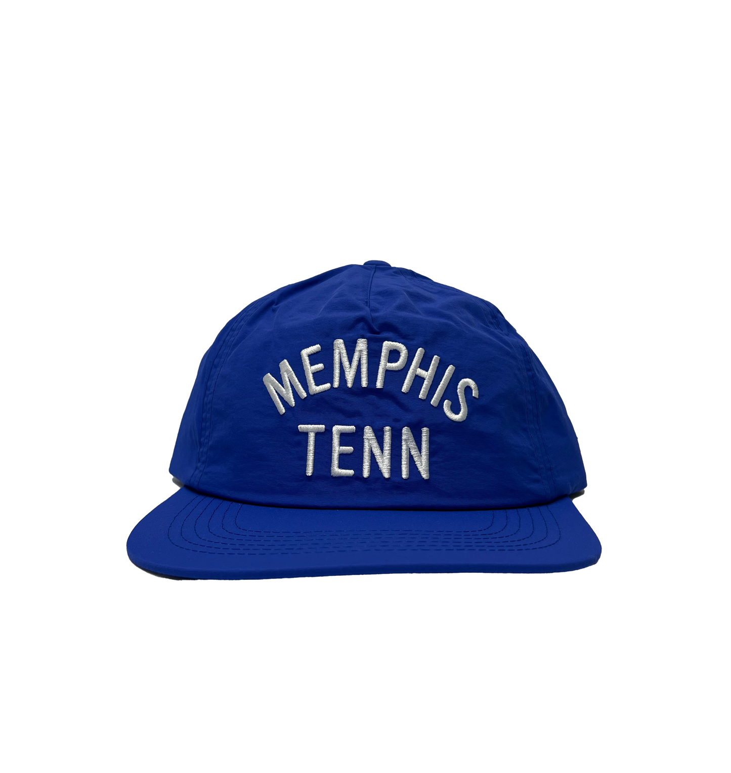 A Memphis Tenn Nylon Hat Royal Blue with "memphis tenn" embroidered in white, placed on a striped gray background by Choose901 Merch Shop.