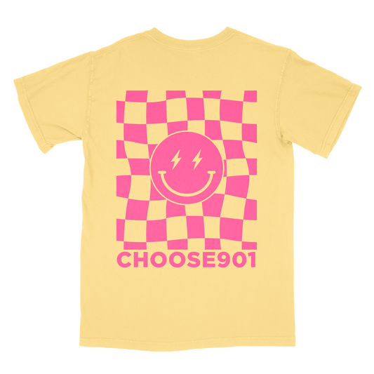 A yellow Choose901 Merch Shop t-shirt featuring a pink and orange checkered pattern with a smiling sun design and the text "choose901" in bold letters.