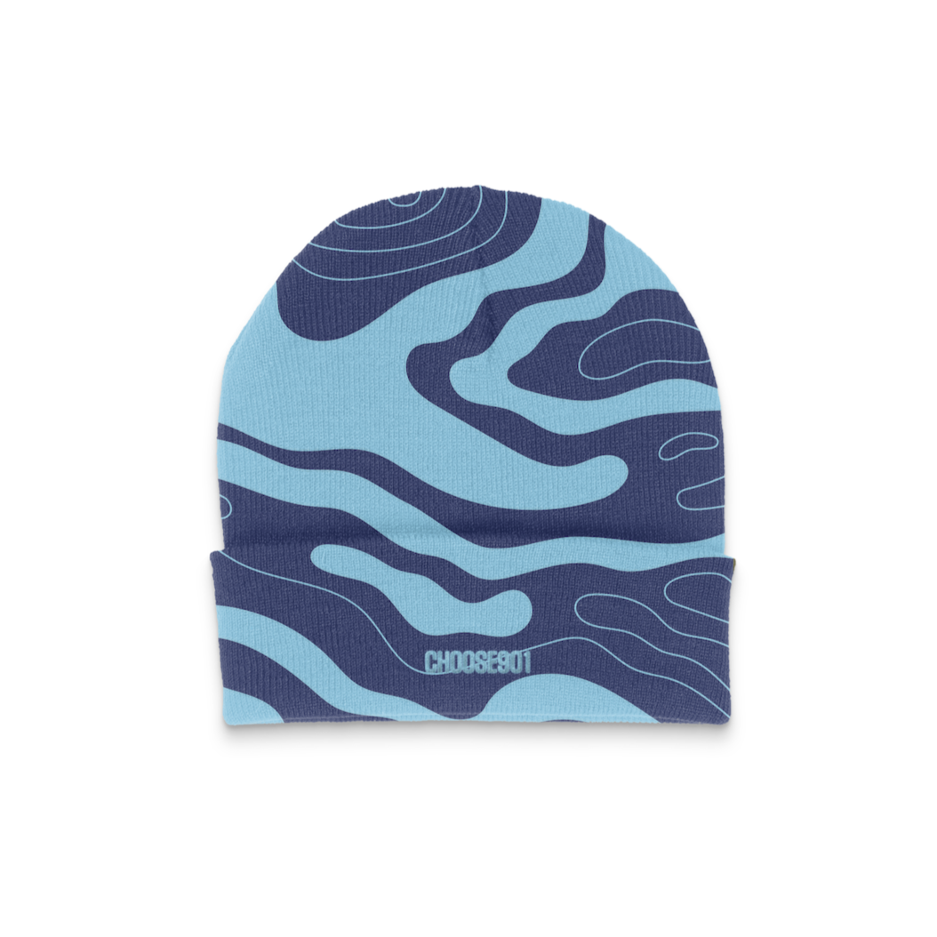 The "Something's in the Water Tech Beanie" from Choose901 Merch Shop is a stylish noggin warmer featuring an abstract wave aquifer pattern on a white background, accented with blue and navy colors.