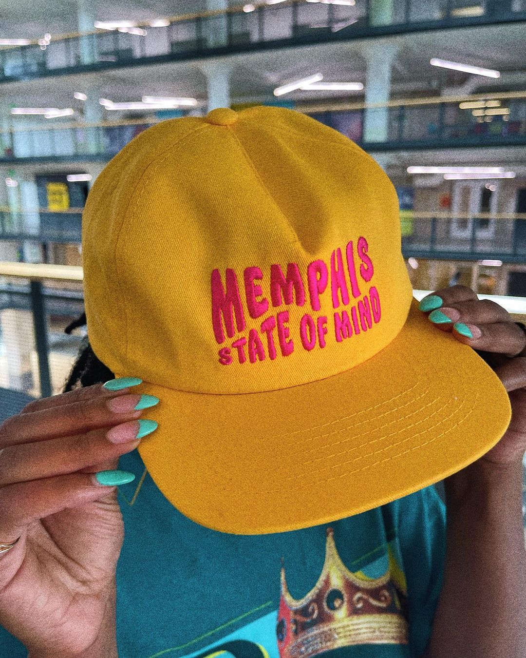 A person holding a MEMPHIS STATE OF MIND HAT from the Choose901 Merch Shop.